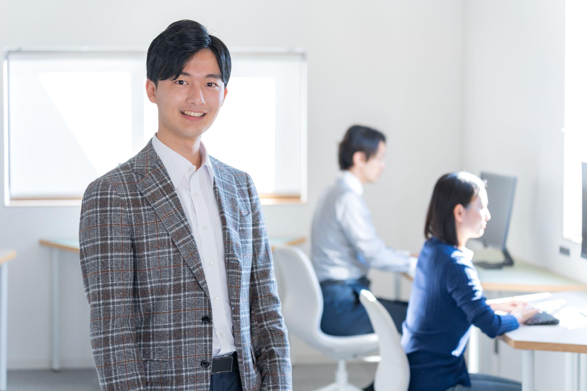 オフィスで微笑むスーツの男性