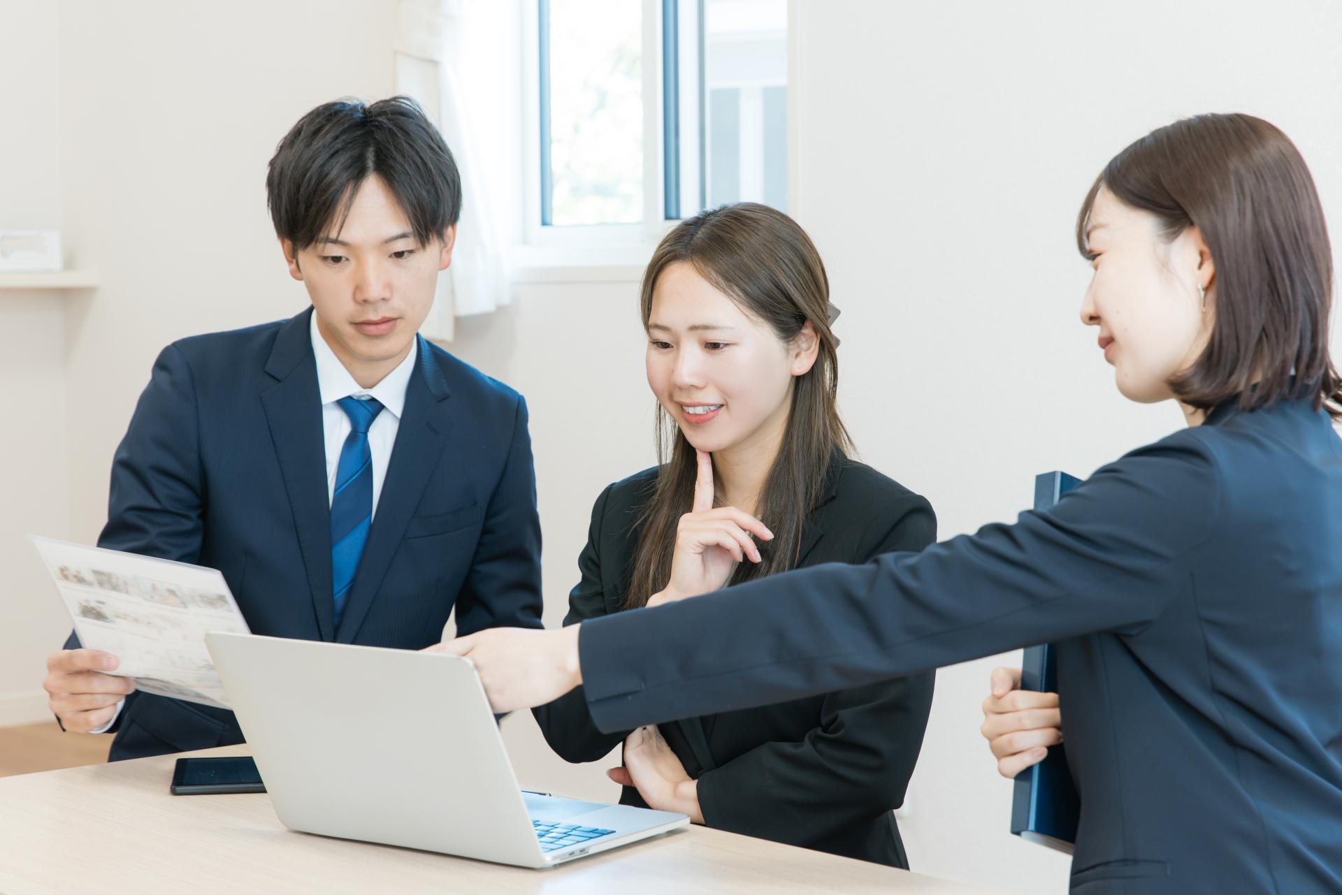PCを見ながら話し合う社員