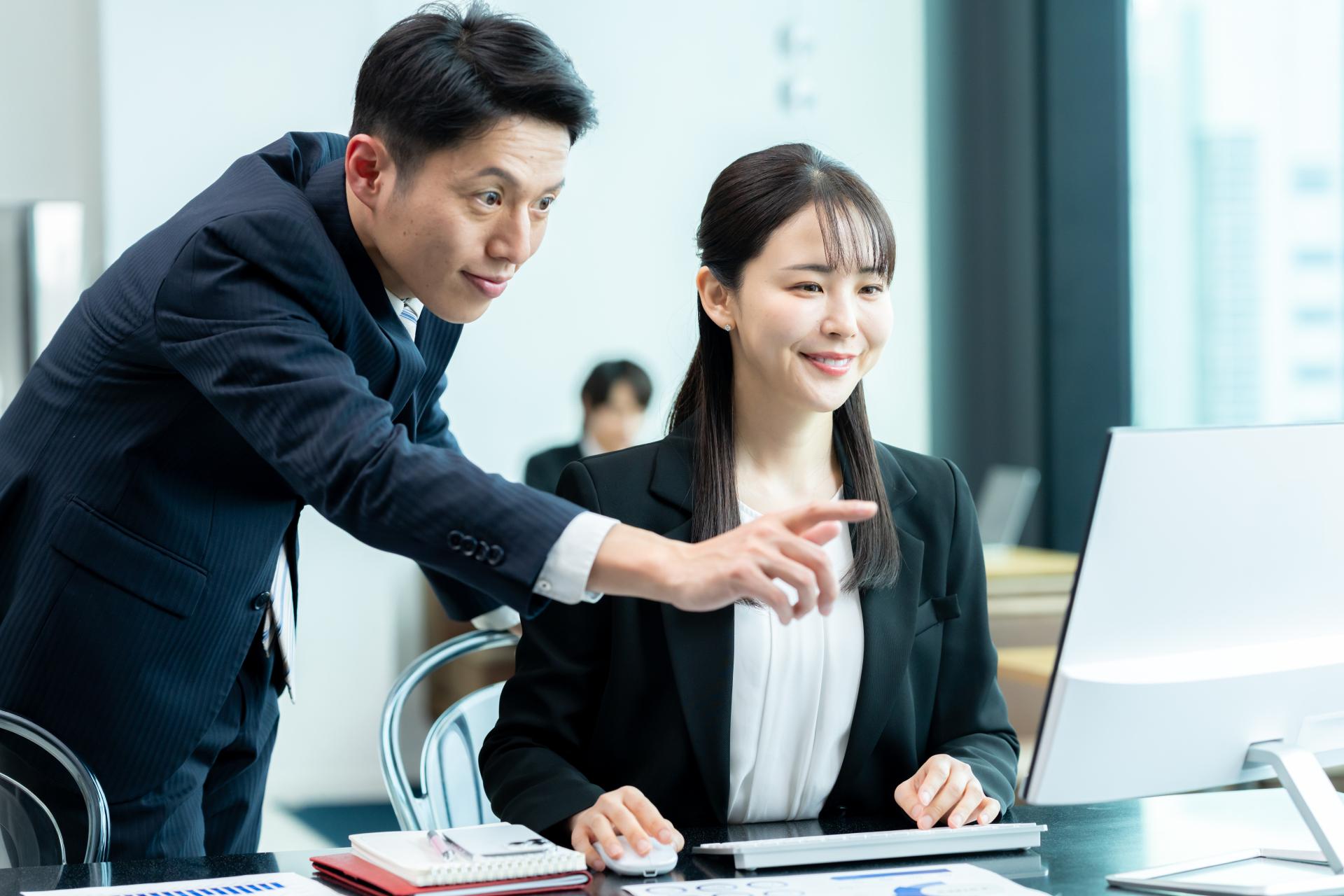 PC画面を指差して説明する社員