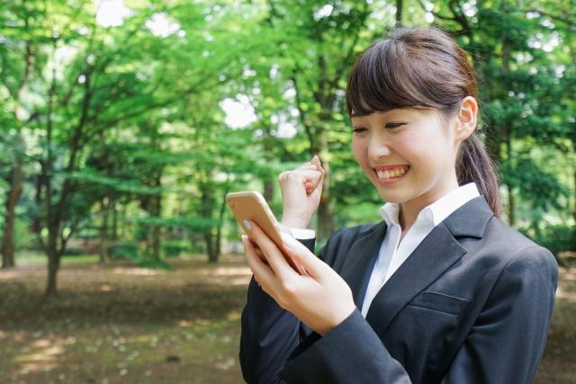 スマートフォンを見て喜ぶ就活生